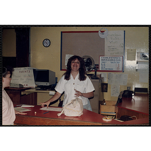 A female staff member smiles for the camera at the front desk in the Charlestown Clubhouse