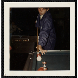 A boy from the South Boston Boys' Club aiming his cue at the cue ball