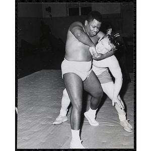 A wrestler puts his opponent in a head lock in the South Boston gymnasium