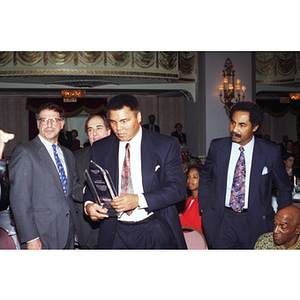 Muhammad Ali walks with his award at the Center for the Study of Sport in Society's annual banquet