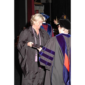 Faculty member presents student with certificate at School of Nursing convocation