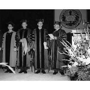 Senator Ted Kennedy stands with three men at Northeastern University's commencement