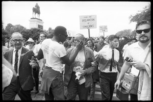 Unidentified man tending to David Dellinger after he was attacked with red paint by right wing counterprotesters (a paint-smeared Staughton Lynd stands to right of Dellinger): Assembly of Unrepresented People peace march on Washington