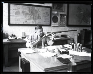 T. J. S. Boake, examining a rifle