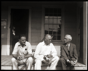 Unidentified man, Nelson P. Brown, and Mr. Loveland (l. to r.), seated on a porch