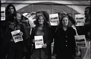 Free Spirit Press crew standing by bus, clutching issues of the magazine