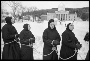 Protesters from Bread and Puppet Theater, hands bound and dressed in cloaks and masks, during a demonstration against the invasion of Laos at the Vermont State House