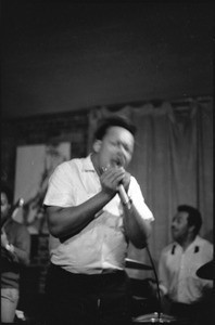 James Cotton at Club 47: James Cotton holding harmonica and microphone onstage, with guitarist Luther Tucker partly out of frame at left, and Francis Clay playing drums at right