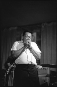 James Cotton at Club 47: James Cotton playing harmonica with his eyes closed onstage with Luther Tucker playing guitar behind him