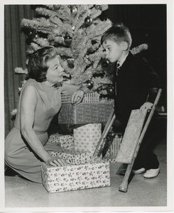 Mrs. Kilbourne with young client in front of Christmas tree