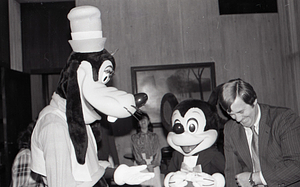 Man with Disney characters Mickey Mouse and Goofy