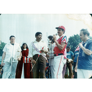 A man with a microphone holds a large trophy at the Festival Puertorriqueño