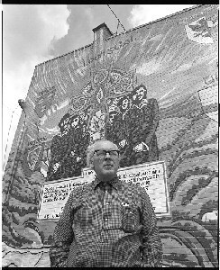 Fr. Des Wilson pictured in Ballymurphy, Belfast in front of wall mural honouring PIRA men killed by S.A.S. Special Air Service (undercover British soldiers) in Loughgall, Co. Armagh