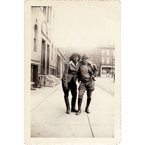 Two unknown individuals pose on an unidentified street