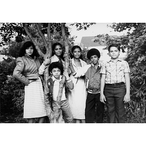 Group photograph of six children standing outside under a tree.