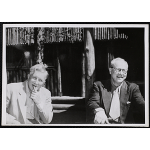 Arthur T. Burger, at right, seated with an unidentified man in front of a building