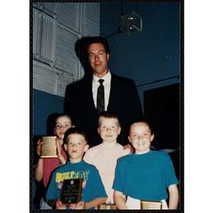 Former Boston Celtic Dave Cowens posing for a group picture with four boys and girls at a Kiwanis Awards Night