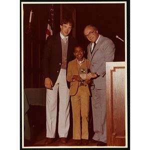 Bernard White receives an award from Robert Cleary, Overseer of the Boys' Clubs of Boston, at right, and an unidentified man