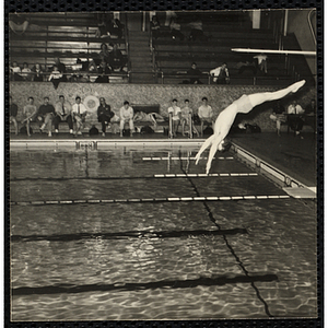 A boy performs a dive during a Boys' Club swimming championship. A caption on the back of the photograph states "Beautiful backdive"