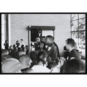 Boston Police officers perform with microphones for children during a public relations event