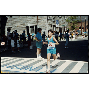 A woman crosses the finish line during the Battle of Bunker Hill Road Race