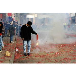 Smoke surrounds a man holding a firecracker during a celebration of the Chinese New Year in Boston's Chinatown