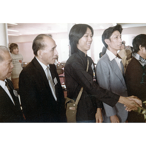 Member of the Chinese Progressive Association stands with You King Yee and shakes the hand of a Chinese diplomat after arrival in Boston