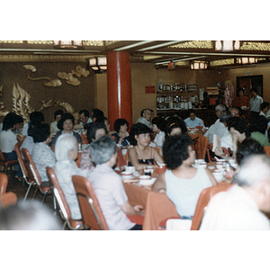 Members of the Chinese Progressive Association and others sit at restaurant tables during an event held for a visit of the Chinese Ambassador to the United States