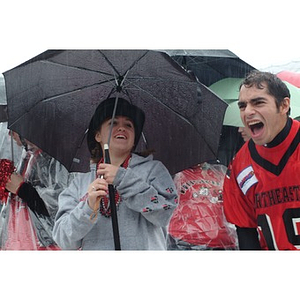 Heidi Buchanan, the Mayor of Huntington Avenue, cheers on the team from beneath her umbrella