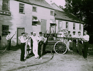 Firefighters with water pump and hose, 1900