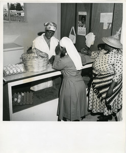 A woman egg producer at the Maseru Egg Circle waits, as clerk totes up payment due her. Every year about 100,000 eggs are given to schools as repayment of pountry equipment supplied by UNICEF