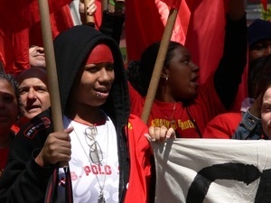 Marchers with Youth United for Change banner, holding flags, marching in the streets to oppose the war in Iraq