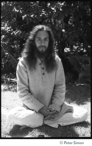 Gangadhar: portrait of the tabla player with Amazing Grace and member of Ram Dass satsang, seated in a lotus position in front of a rhododendron