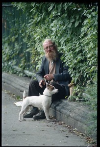 Man and his dog seated by an iron fence on a Dublin street