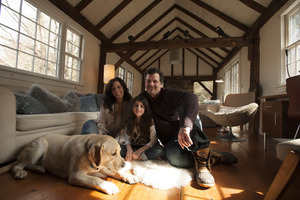 Sheffield House: Martin Canellakis, Faith Cromas, daughter Eva, and dog Poppy in their living room, Sheffield, Mass.