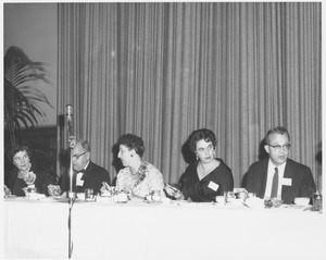 Unidentified woman, Phil Whitmore, Marion Niederpreum, Miss Merchant, and John Lederle sitting at banquet table eating