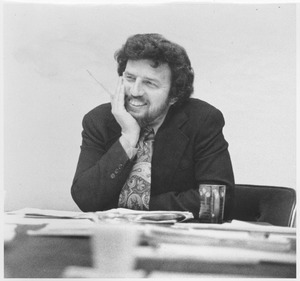 Robert Corrigan sitting at a desk, smiling