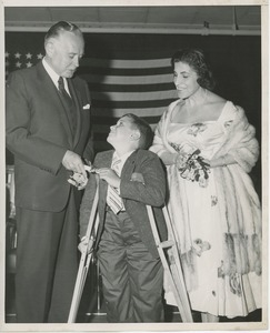 Young boy on crutches receiving diploma at Institution Day