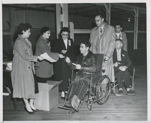 Man in wheelchair receives papers