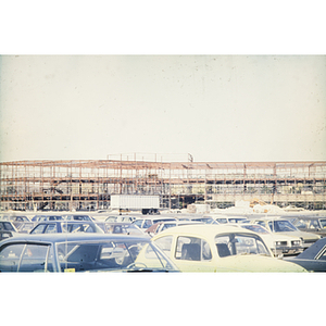 Parking lot and skeleton frame of a building under construction