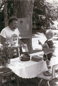 Jack Clarke, volunteer, selling cookbooks at bake sale 1981