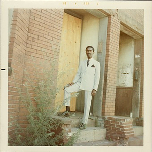Reverend Michael E. Haynes stands on the stairs of an abandoned building in Lower Roxbury