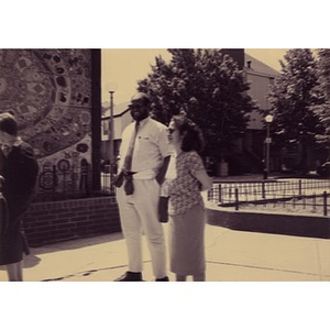 Clara Garcia and an unidentified man standing by the ceramic tile mural in the Plaza Betances.