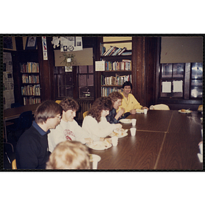 Staff members eating at a table, including Jerry Steimel, seated on the far left