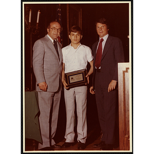 Kevin Cunningham receives an award from Robert Cleary, Overseer of the Boys' Clubs of Boston, at left, and an unidentified man