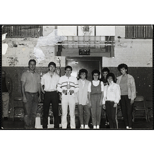 Group portrait of three men and five women posing with a Boys & Girls Club basketball tournament trophy