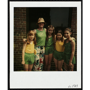 A woman and four girls in green and yellow posing outside a building during a Boys & Girls Club event