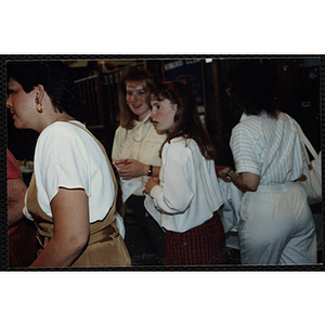 Two young women standing together while others walk past during a Charlestown Boys & Girls Club event