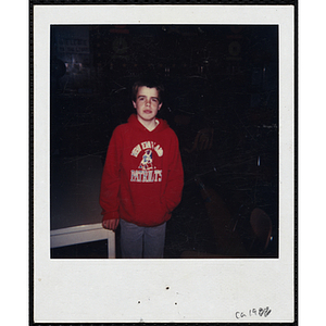 A boy posing in a red hooded sweatshirt with the New England Patriots logo at the Boys and Girls Club