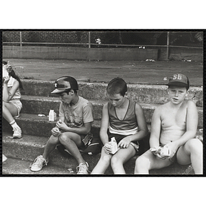 Boys sit on stairs at a carnival